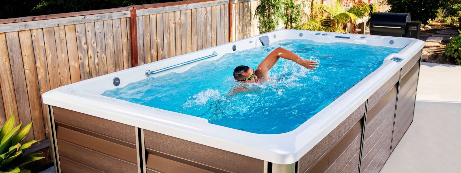 Swim spa set up in backyard with swimmer