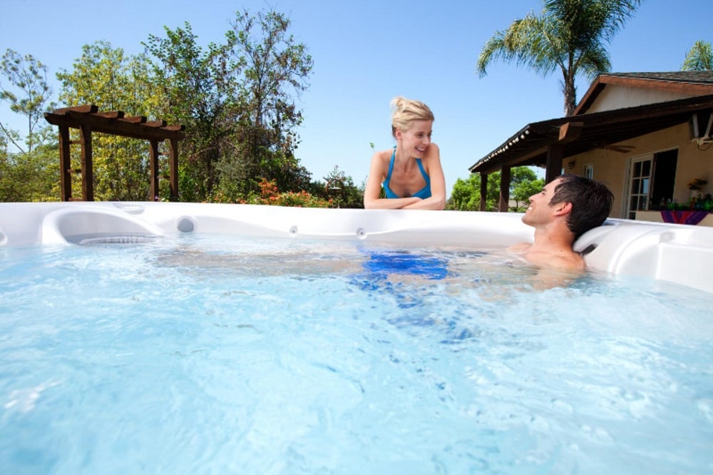 A man in a hot tub talking to a woman