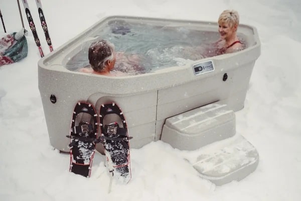people resting in hot tub after skateboarding in winter